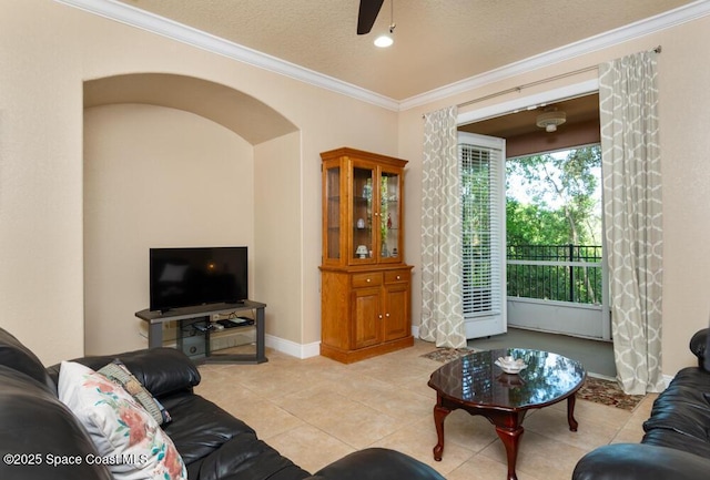 living room featuring light tile patterned floors, arched walkways, ceiling fan, ornamental molding, and a textured ceiling