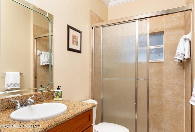 full bathroom featuring vanity, a shower stall, and toilet