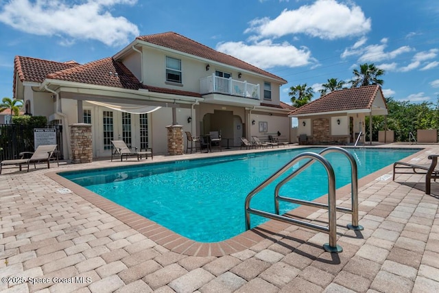 pool featuring a patio, french doors, and fence