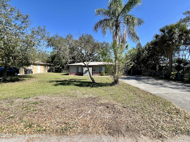 single story home featuring concrete driveway and a front yard