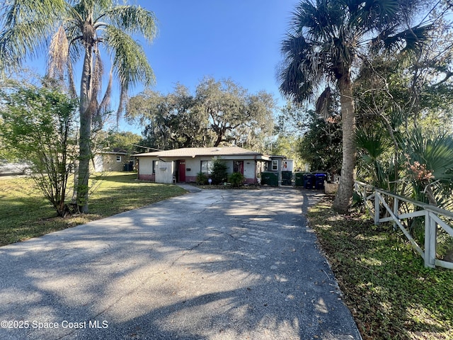 view of front of home with aphalt driveway and a front lawn