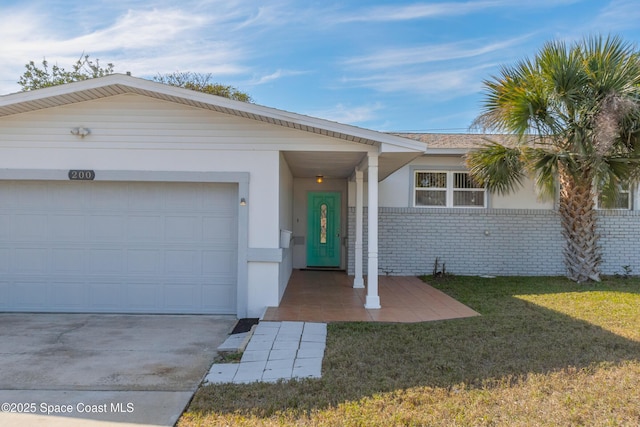 ranch-style house with a garage, brick siding, concrete driveway, stucco siding, and a front lawn