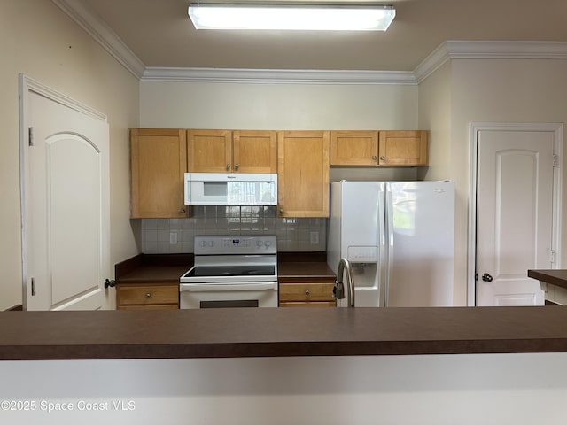 kitchen featuring crown molding, dark countertops, backsplash, a sink, and white appliances