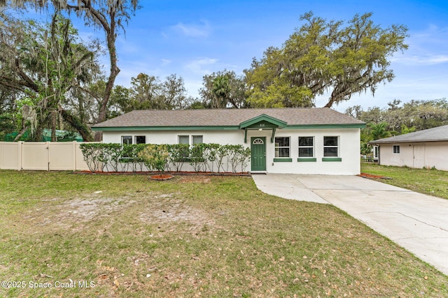 ranch-style home featuring a front yard, fence, and stucco siding