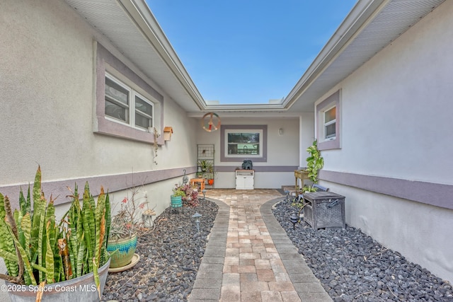 doorway to property featuring stucco siding