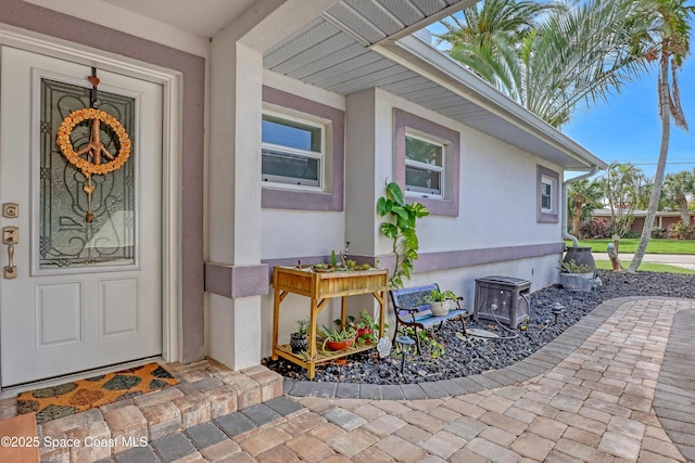 entrance to property featuring central air condition unit and stucco siding