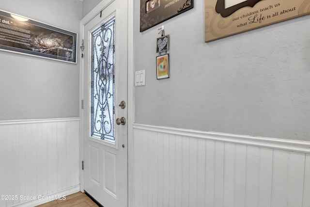 interior space featuring wood finished floors and wainscoting