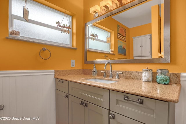 bathroom with a wainscoted wall and vanity