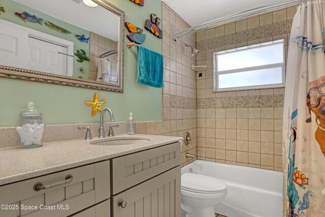 full bath featuring toilet, shower / bath combo with shower curtain, and vanity