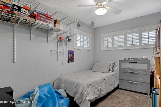 bedroom with carpet flooring, a textured ceiling, and ceiling fan