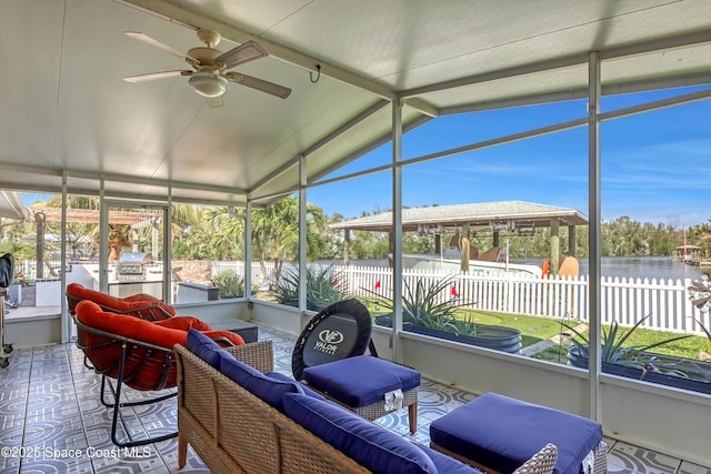 sunroom / solarium featuring a water view, ceiling fan, and vaulted ceiling