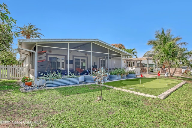 rear view of property with a yard, fence, and a sunroom