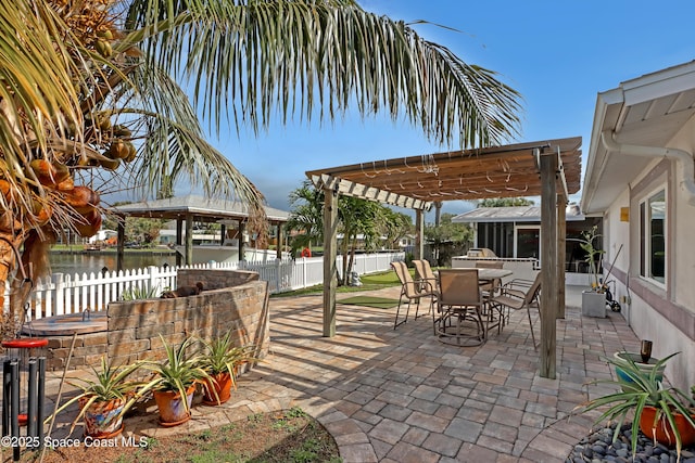 view of patio / terrace featuring outdoor dining area, fence private yard, a pergola, and a water view