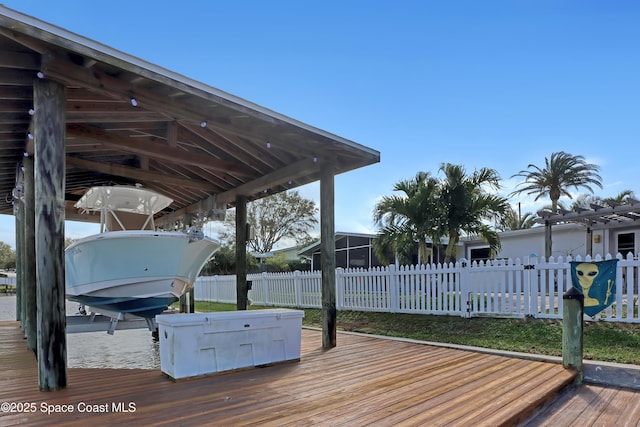 deck featuring boat lift, a boat dock, and fence