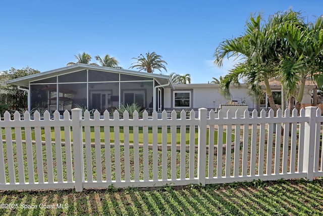 view of front of property with a fenced front yard and a sunroom