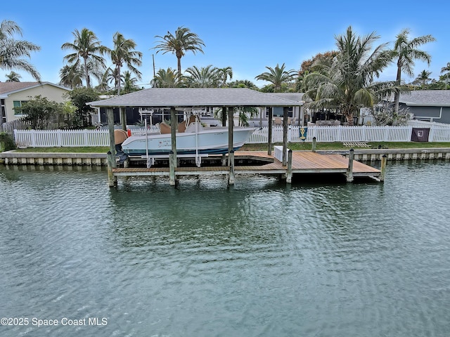 dock area featuring a water view, boat lift, and fence