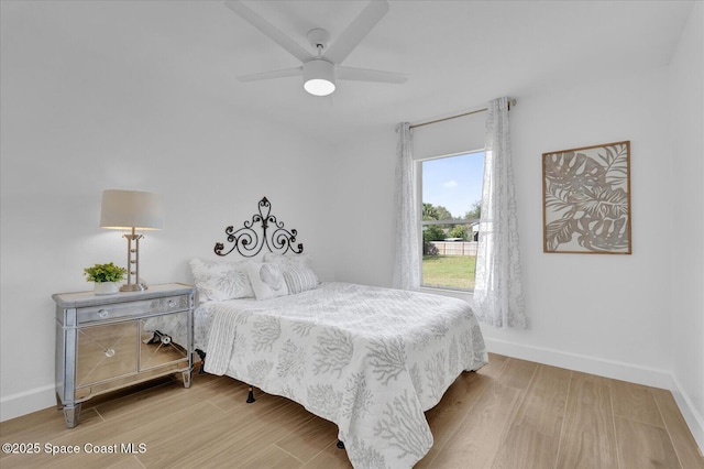 bedroom featuring light wood-type flooring, a ceiling fan, and baseboards