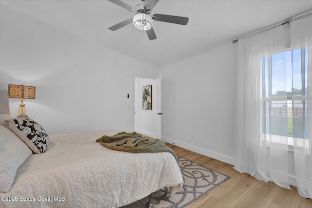 bedroom featuring ceiling fan, light wood-type flooring, and baseboards