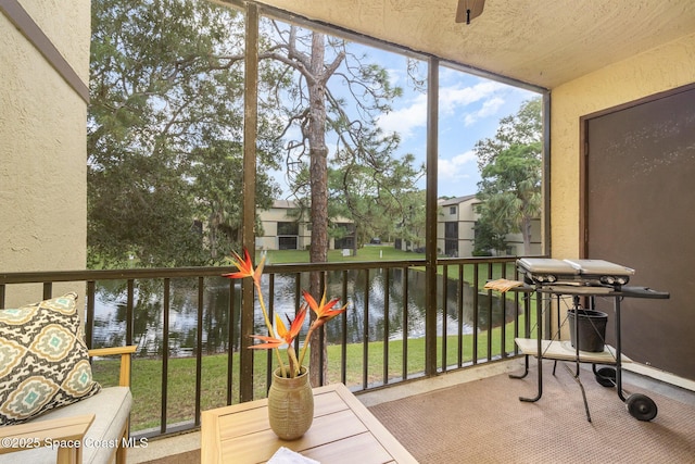 sunroom featuring a water view