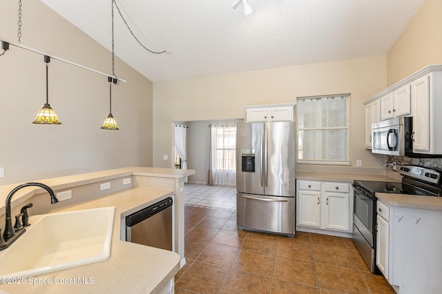 kitchen with white cabinets, decorative light fixtures, light countertops, stainless steel appliances, and a sink