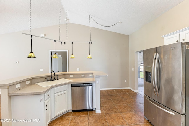 kitchen featuring appliances with stainless steel finishes, light countertops, a sink, and white cabinetry