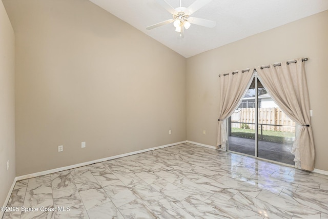 spare room with lofted ceiling, marble finish floor, ceiling fan, and baseboards