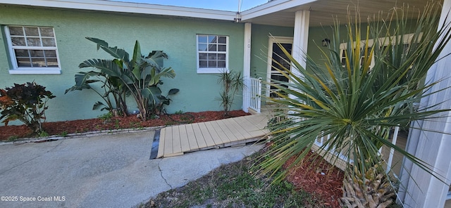 entrance to property featuring stucco siding