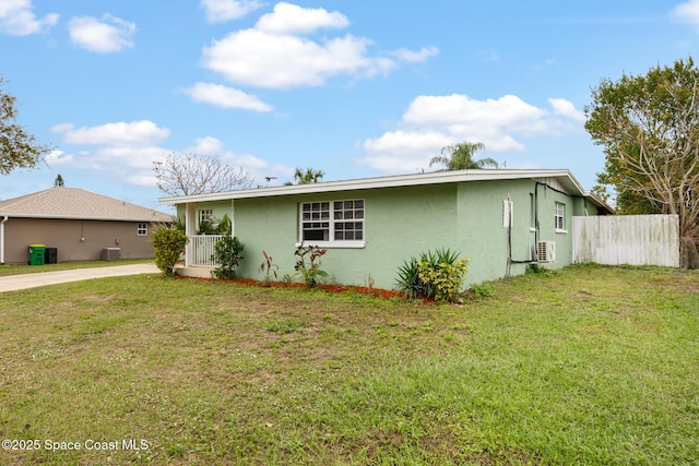 view of front of home featuring a front lawn, ac unit, fence, and stucco siding