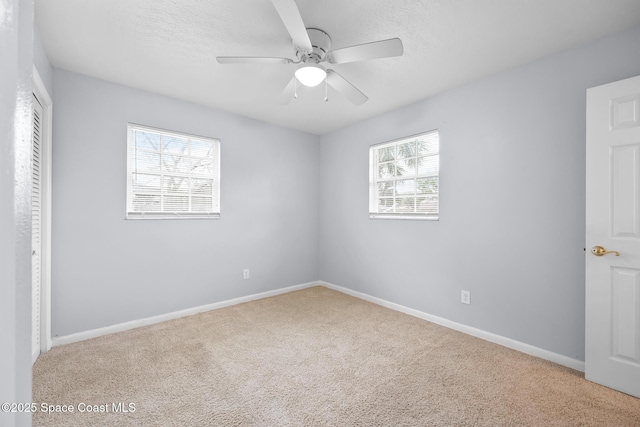 unfurnished bedroom featuring carpet floors, a ceiling fan, baseboards, and a textured ceiling