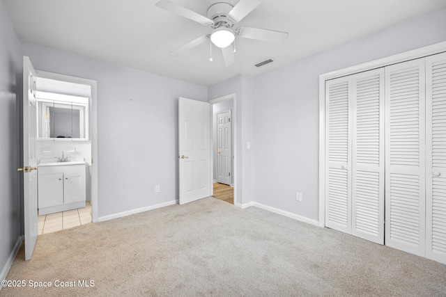 unfurnished bedroom with light carpet, baseboards, visible vents, and a closet