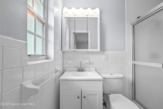 full bath featuring vanity, a shower stall, toilet, and tile walls