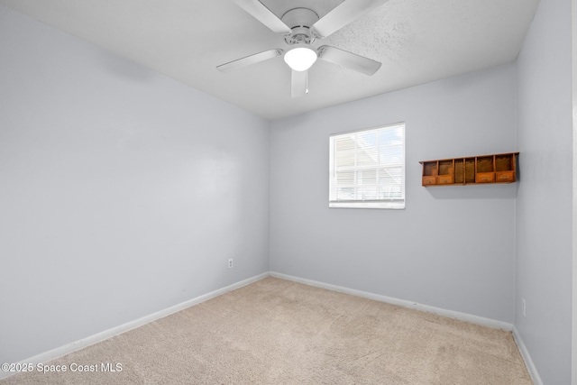 spare room featuring carpet floors, baseboards, and a ceiling fan