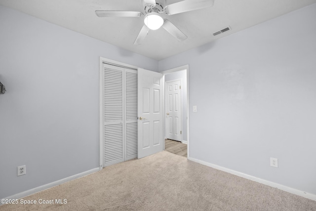 unfurnished bedroom with carpet, a closet, visible vents, and baseboards