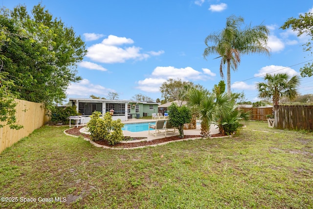 view of yard featuring a fenced in pool, a sunroom, a fenced backyard, and a patio