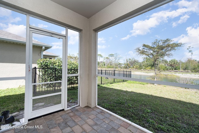 unfurnished sunroom featuring a water view