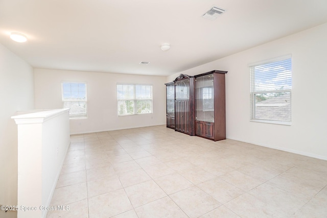 empty room featuring baseboards and visible vents