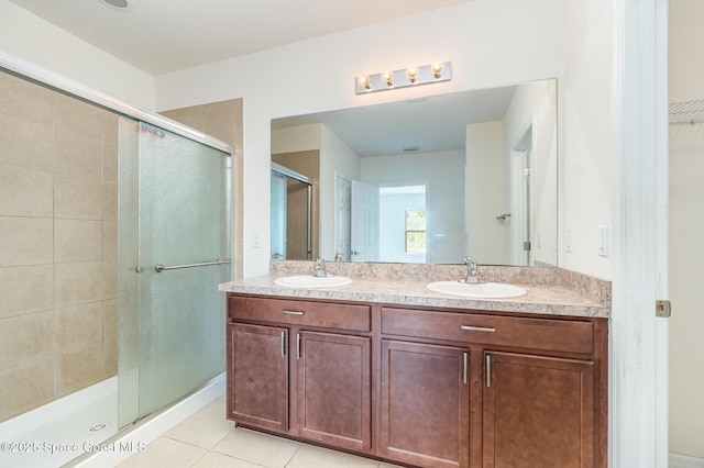 bathroom featuring a stall shower, a sink, and tile patterned floors