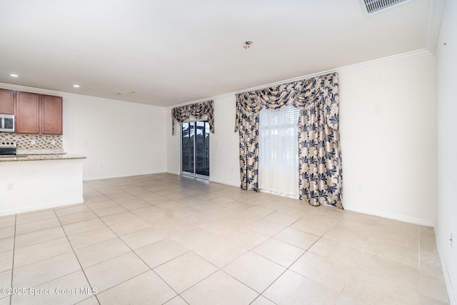 spare room featuring baseboards, visible vents, crown molding, and light tile patterned flooring