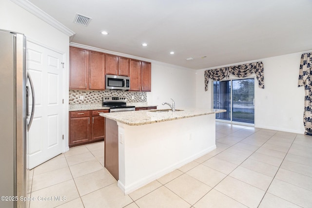 kitchen with light tile patterned floors, a center island with sink, light stone counters, stainless steel appliances, and a sink