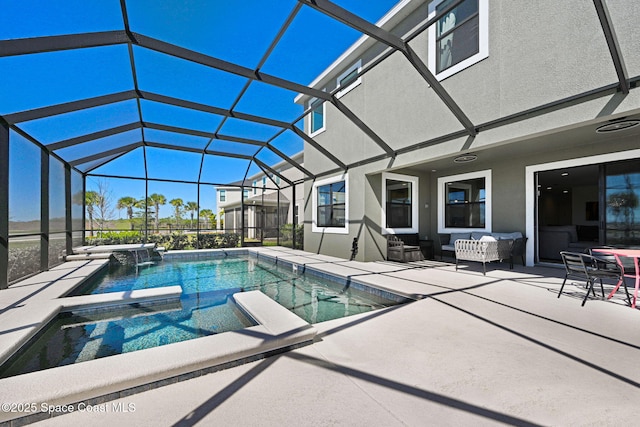 view of swimming pool with a patio, a pool with connected hot tub, and glass enclosure