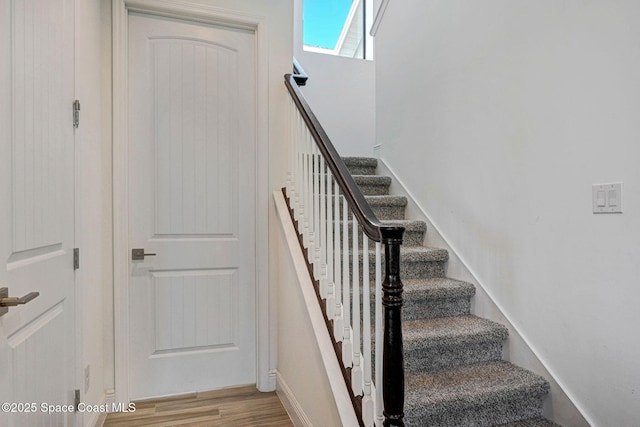 stairs featuring baseboards and wood finished floors