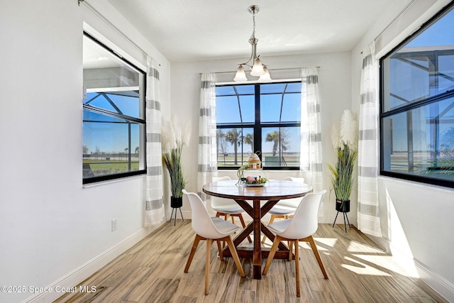 dining space with baseboards and wood finished floors