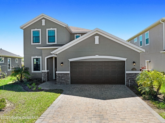 view of front of property featuring decorative driveway, stone siding, an attached garage, and stucco siding