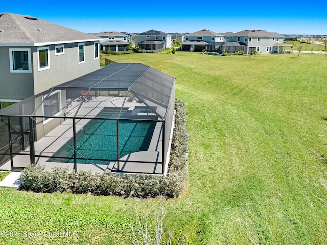 outdoor pool with glass enclosure, a yard, a patio area, and a residential view