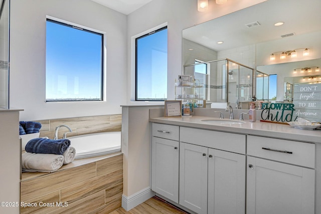 full bathroom featuring visible vents, vanity, a shower stall, and a wealth of natural light