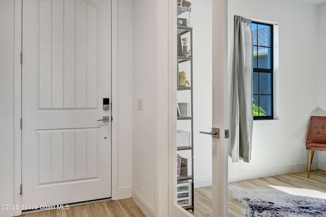 entryway with light wood-type flooring and baseboards