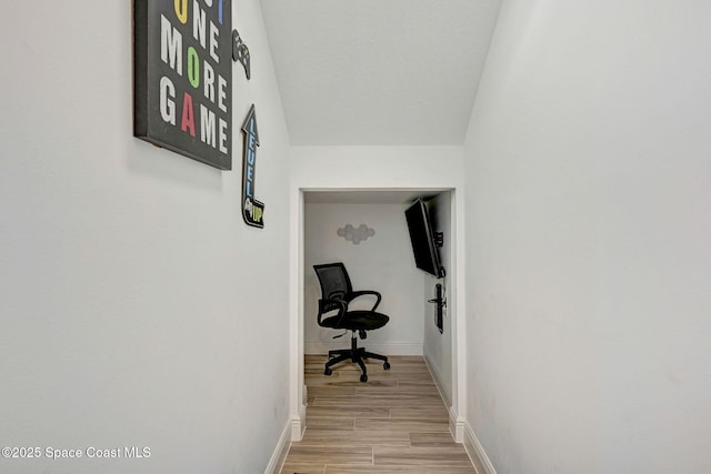 hallway featuring light wood-style floors and baseboards