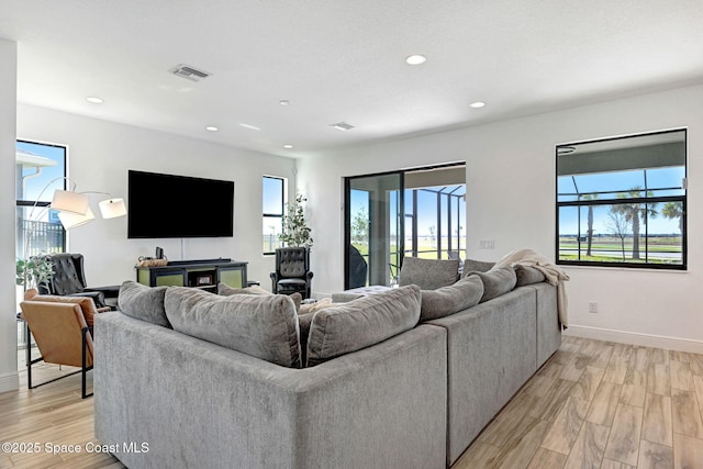 living room with visible vents, plenty of natural light, and light wood finished floors