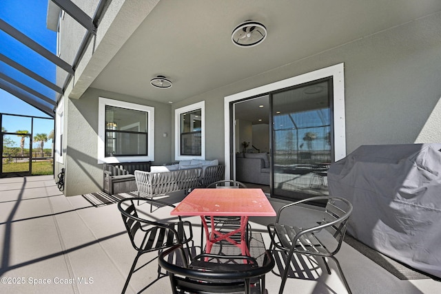 view of patio / terrace with outdoor dining area, glass enclosure, and an outdoor living space