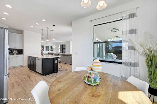 dining room with light wood finished floors and recessed lighting